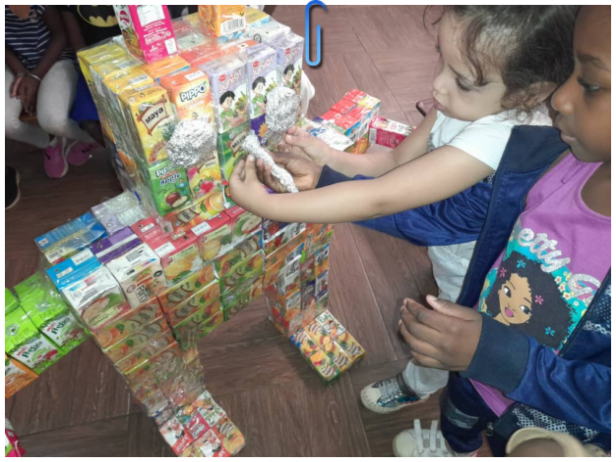 Une élève de moyenne section participe à un atelier Recycl’Art au LIFE : création d’un robot à partir de briques de jus recyclées, dans le cadre du projet EFE3D.